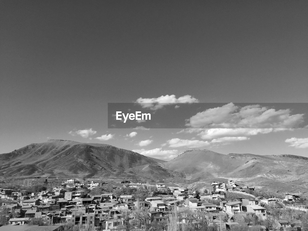 Town by mountains against sky