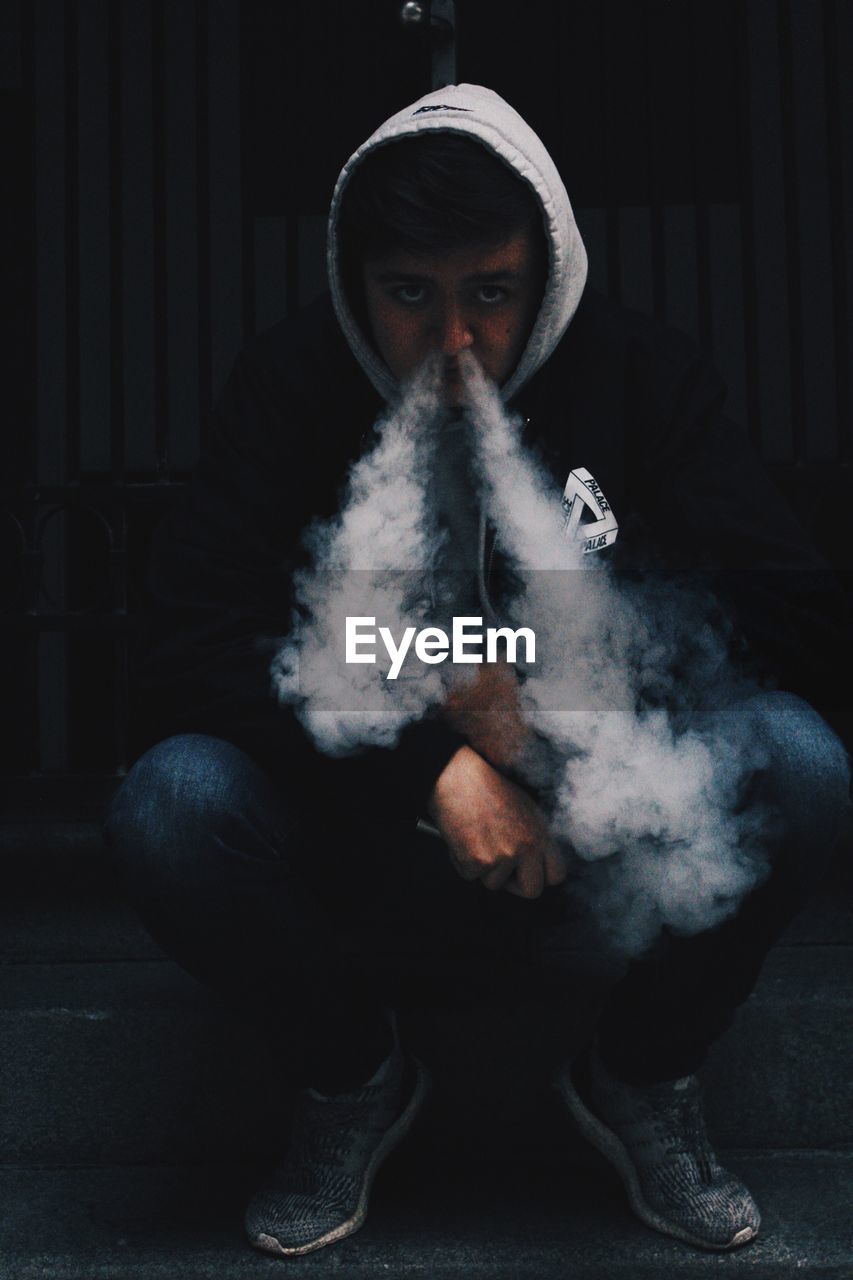 Portrait of man emitting smoke from nose