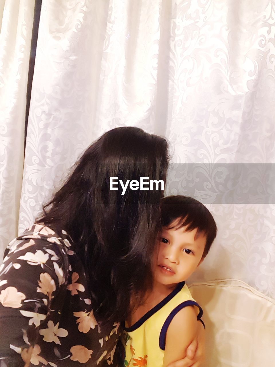 PORTRAIT OF MOTHER AND WOMAN WITH CURTAIN AT HOME