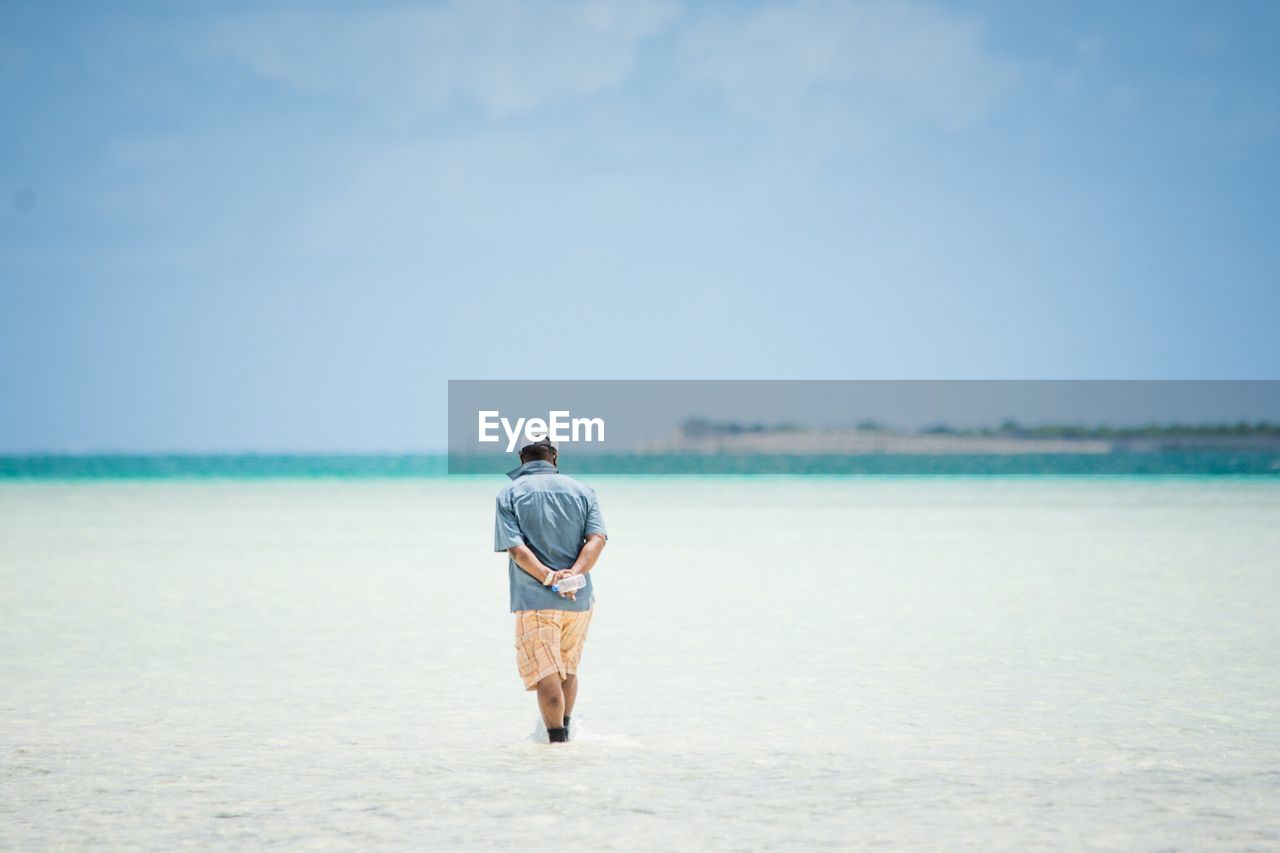Rear view of man walking on beach