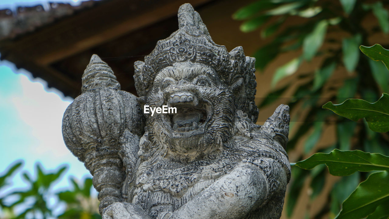 Low angle view of statue against plants