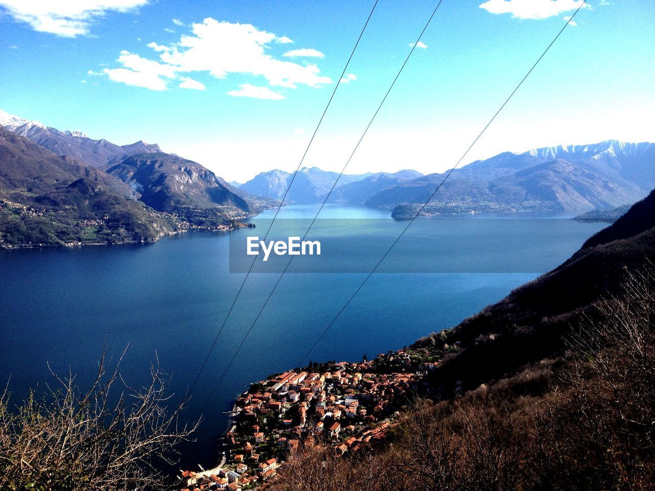 Steel cables over lake against mountains