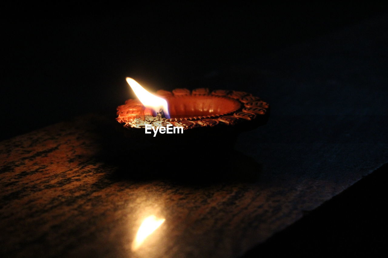 Close-up of burning diya on table