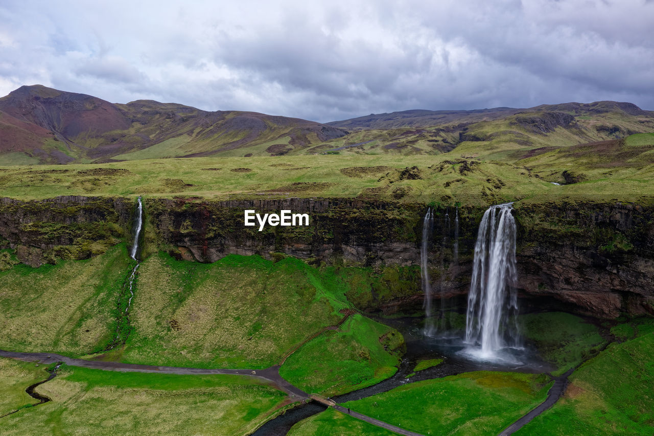 Scenic view of waterfall against sky