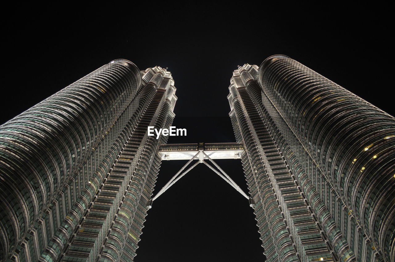 Low angle view of twin towers petronas kuala lumpur against sky at night