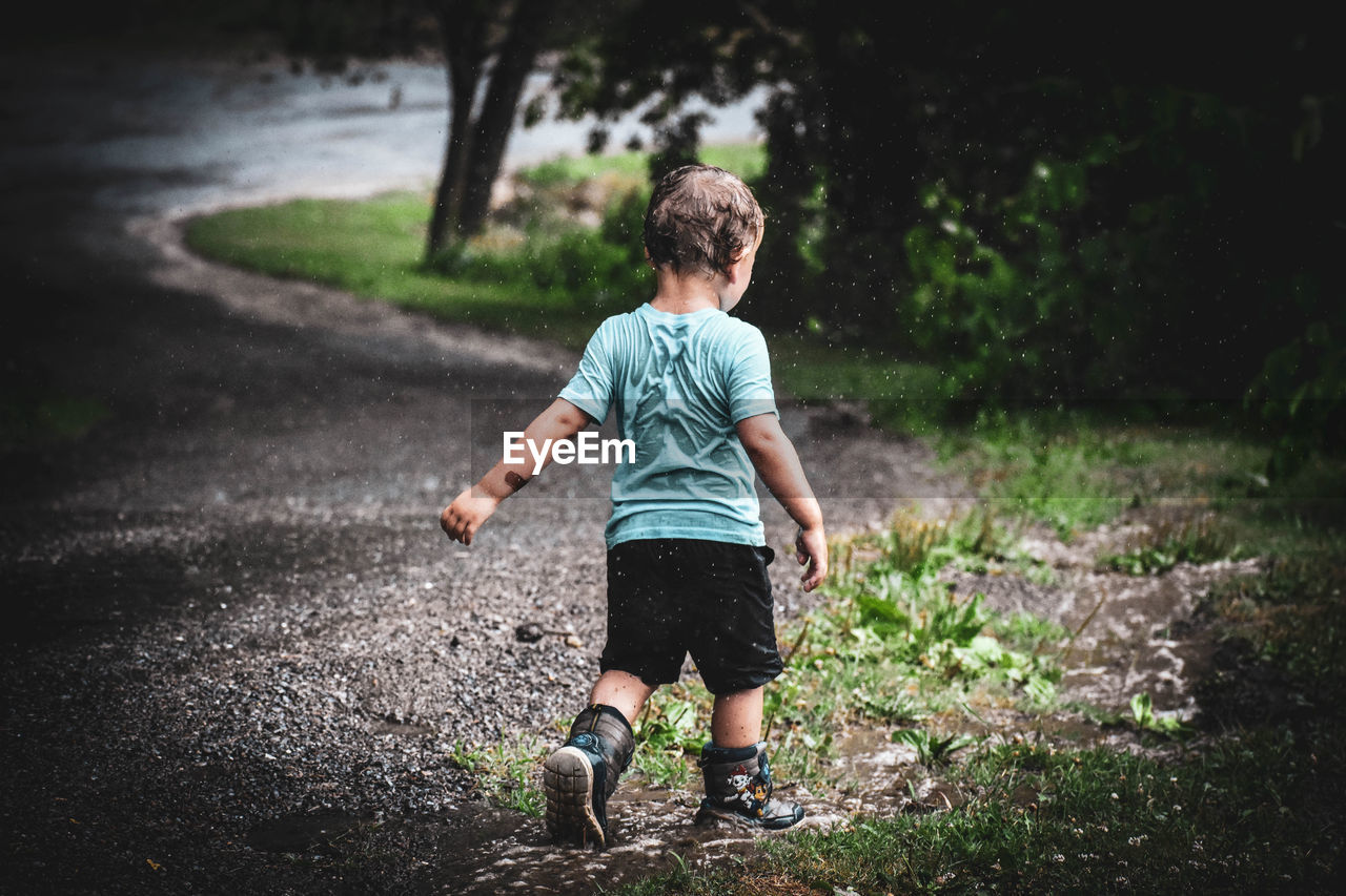 Rear view of boy in the rain