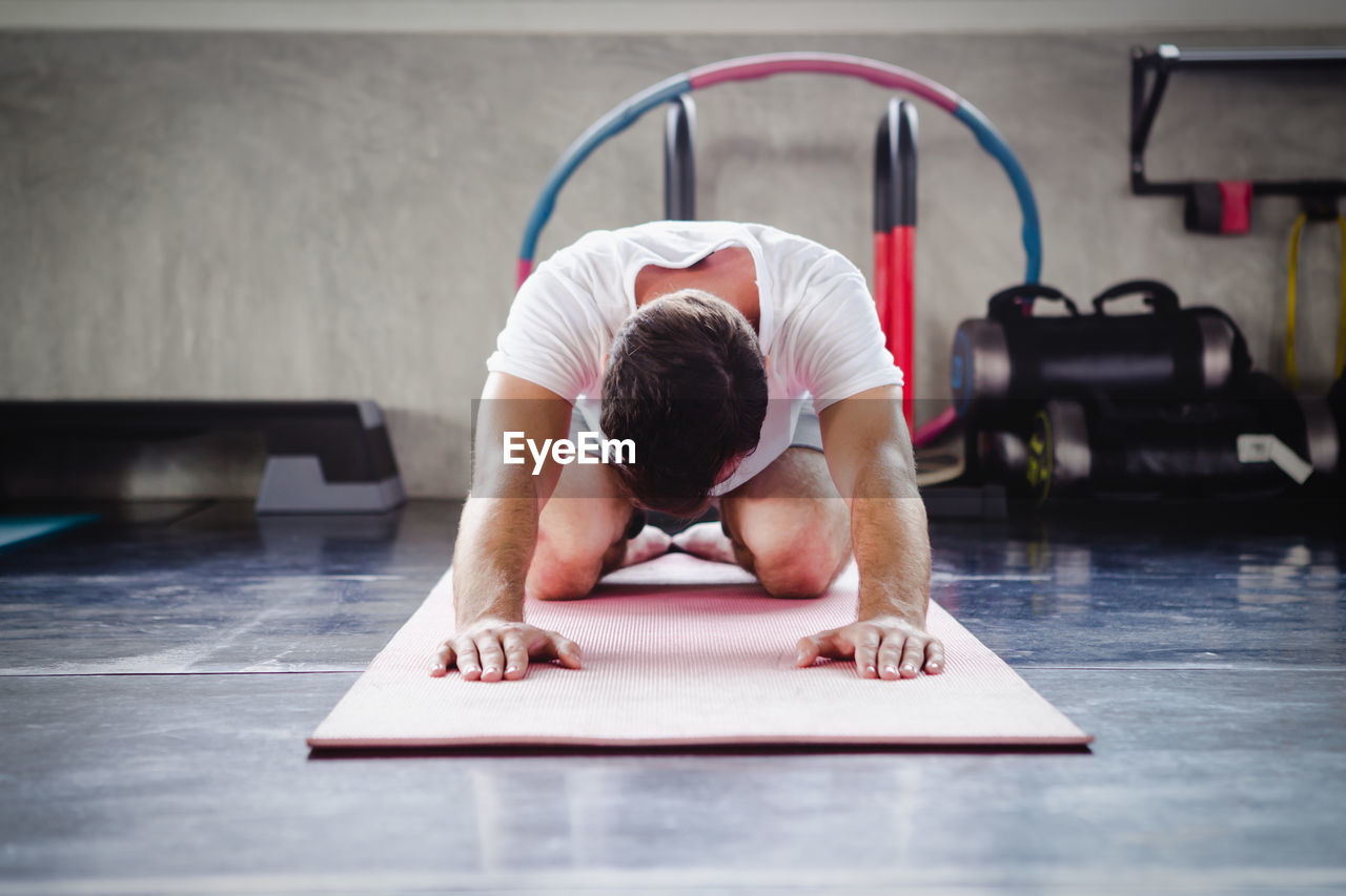 Man exercising on floor at gym