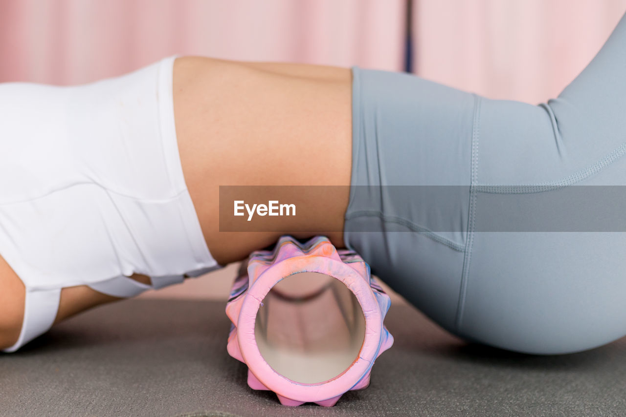 Woman using foam rolling for self-myofascial release density deep tissue massager for relieving pain