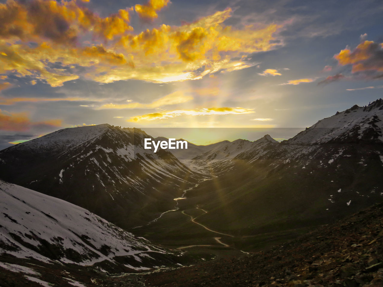 Scenic view of snowcapped mountains against sky during sunset