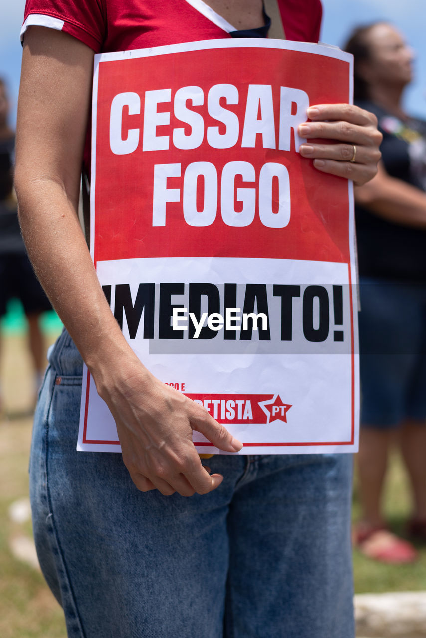 Protesters are seen holding signs during a protest against the war on palestine 