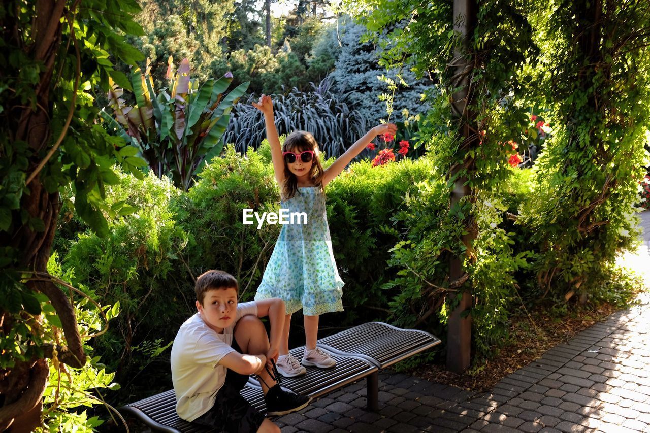 Boy with sister on seat at park