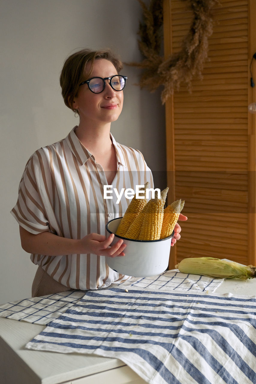 Woman holding corn at home