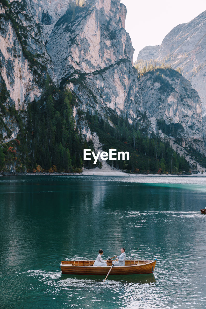 BOATS IN LAKE AGAINST MOUNTAIN