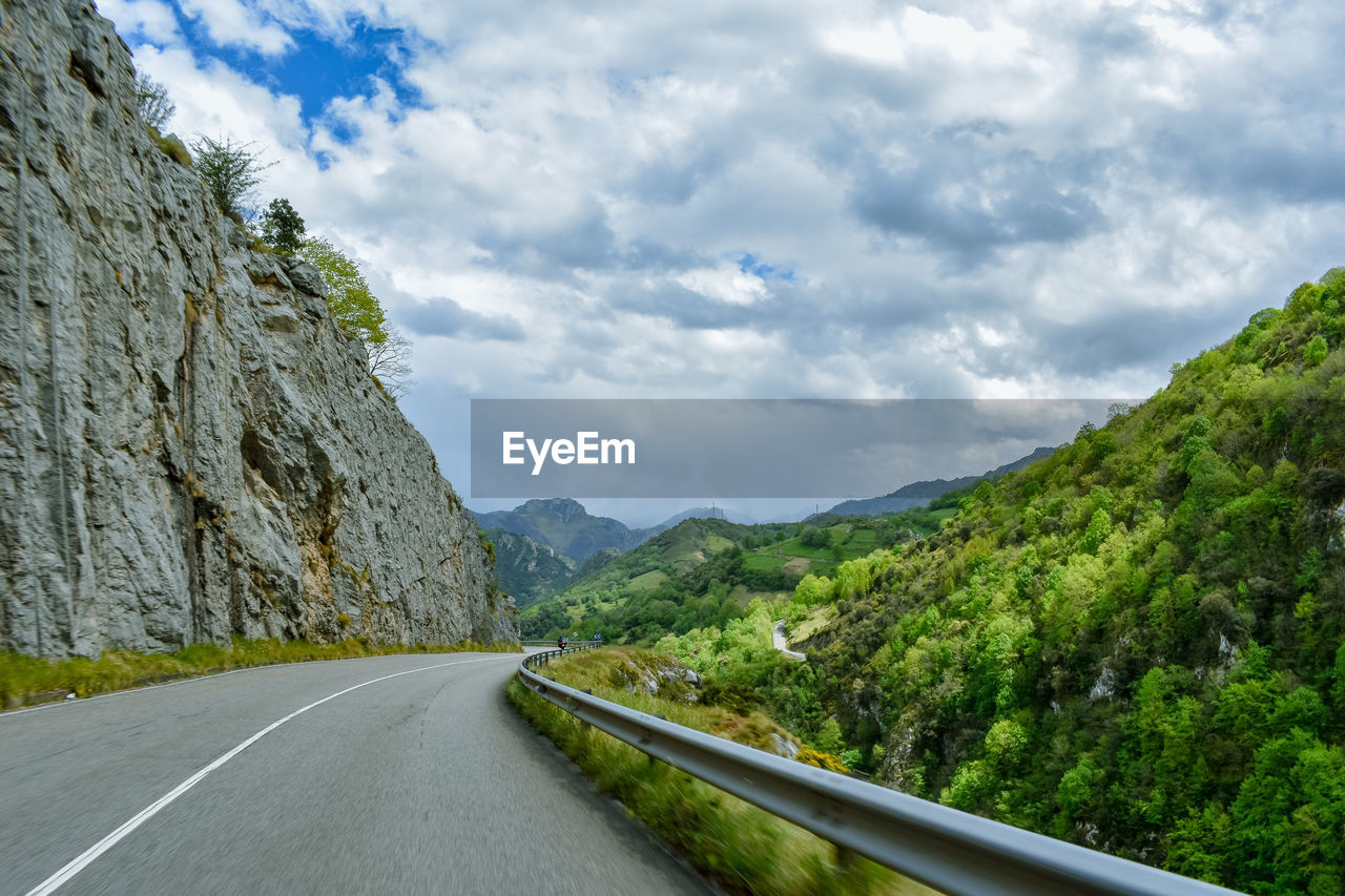 Surface level of road amidst mountains against sky