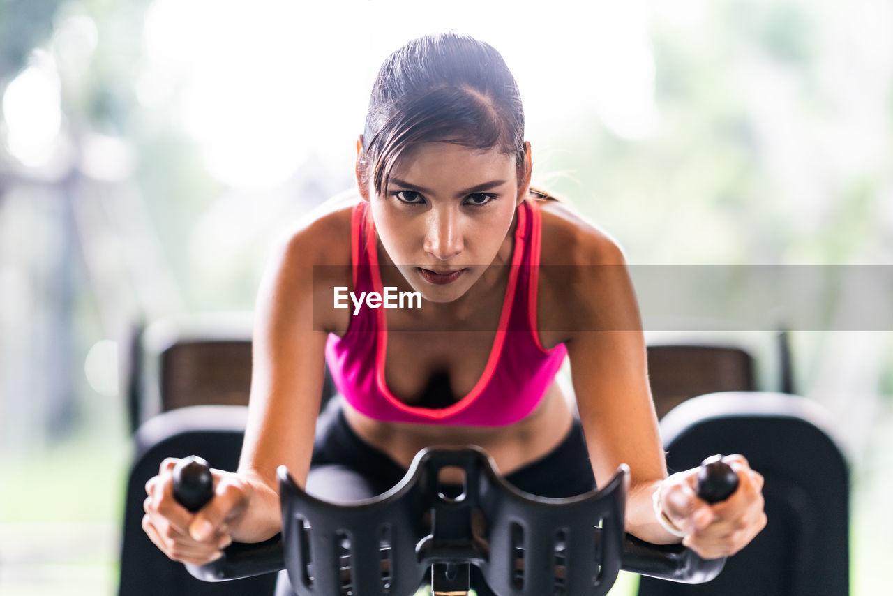 Portrait of young woman exercising at gym