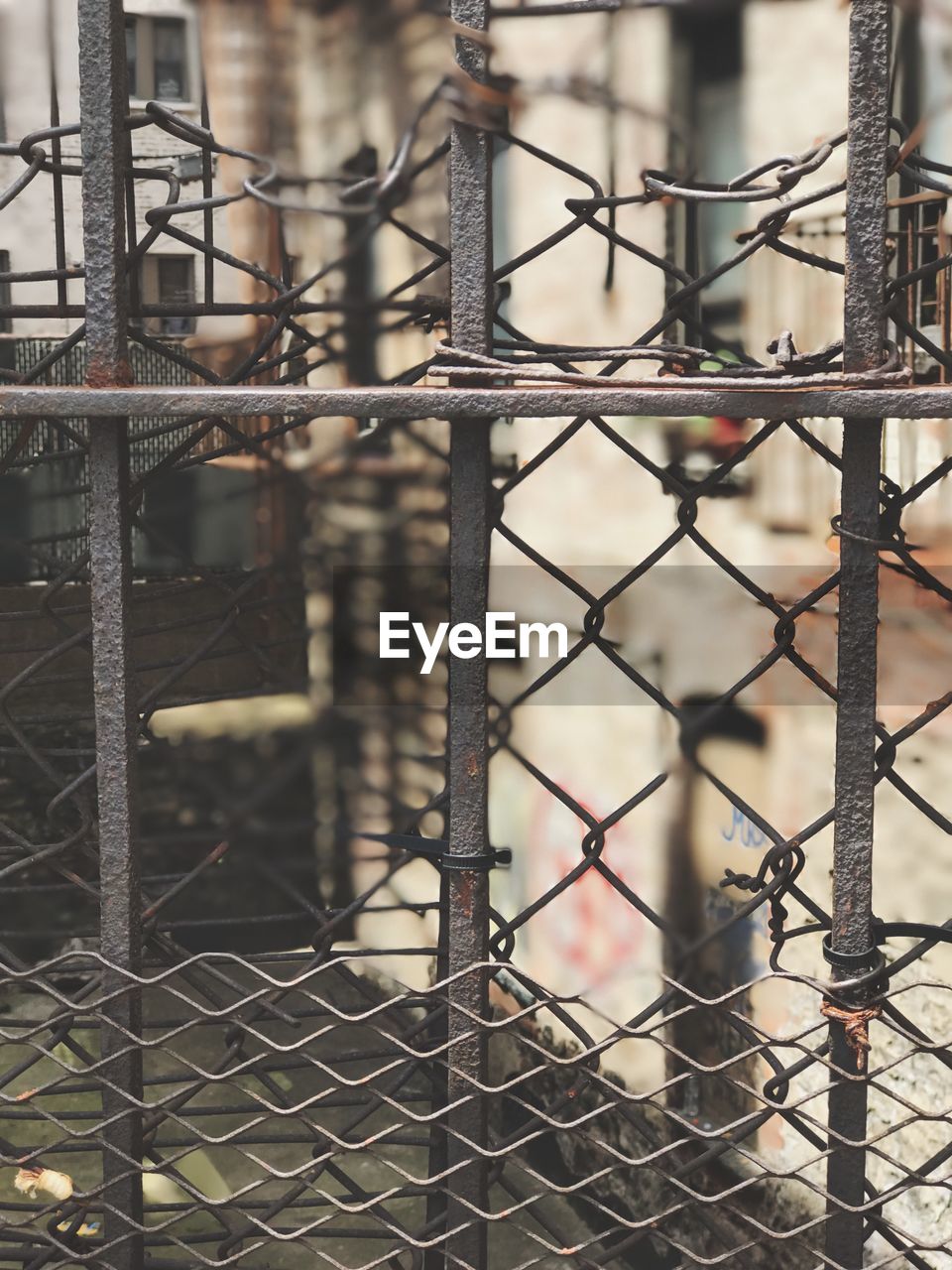 CLOSE-UP OF CHAINLINK FENCE AGAINST METAL