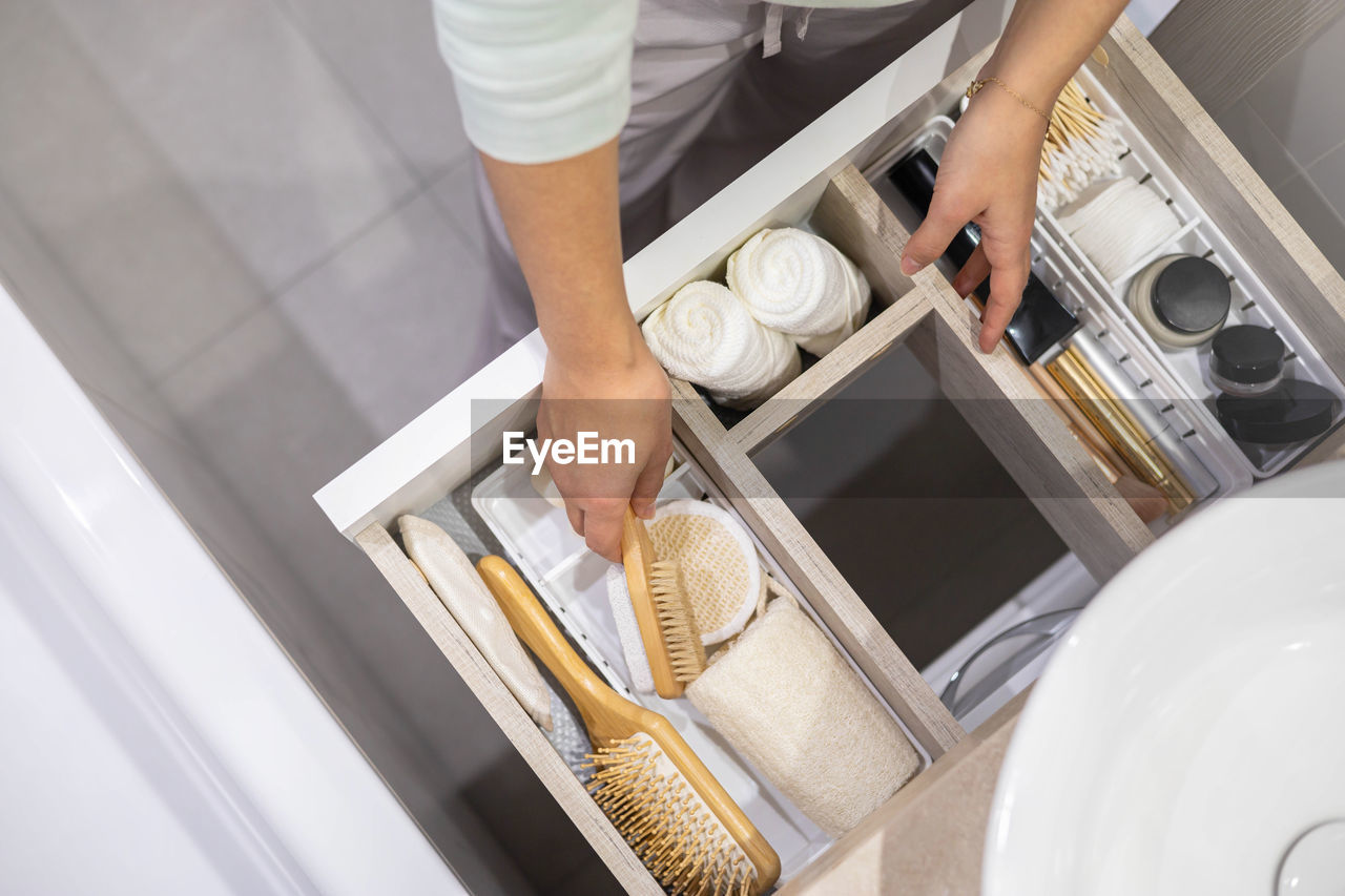 Midsection of woman arranging combs in drawer