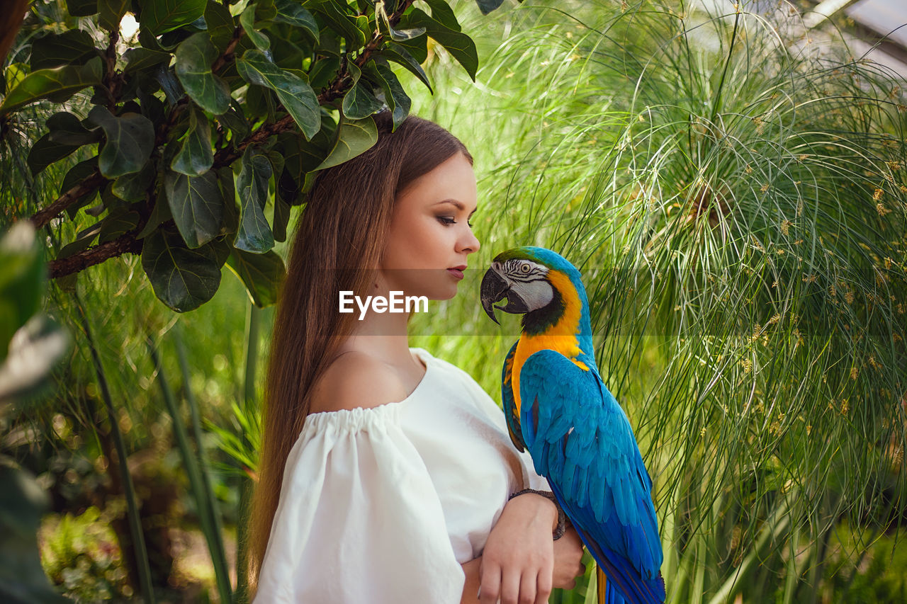 Close-up of woman with parrot