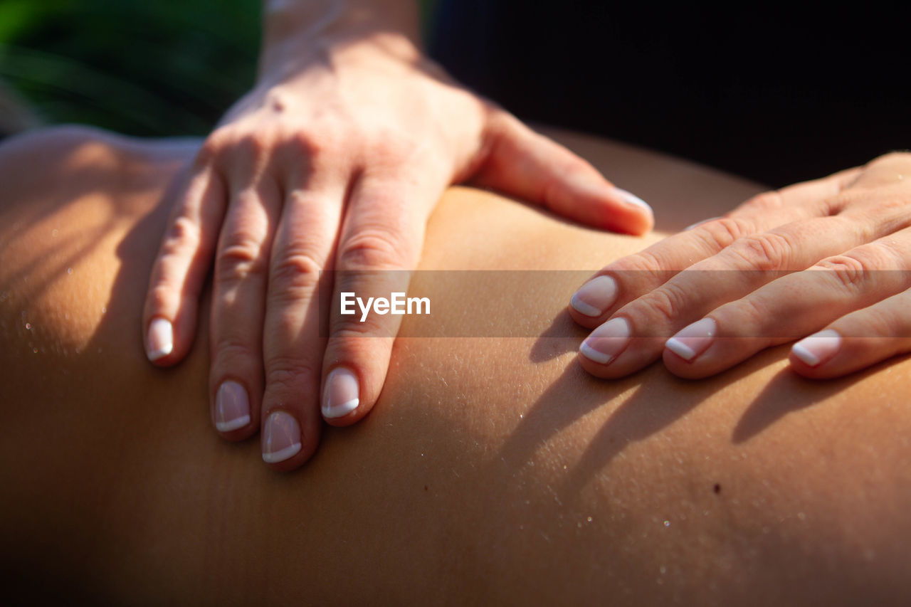 Cropped hands of person massaging customer in spa