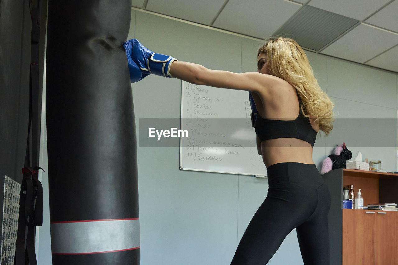 Side view of confident female boxer exercising in gym