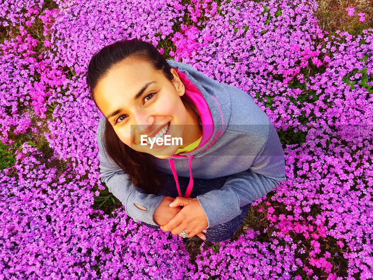 Portrait of smiling woman standing amidst purple flowers