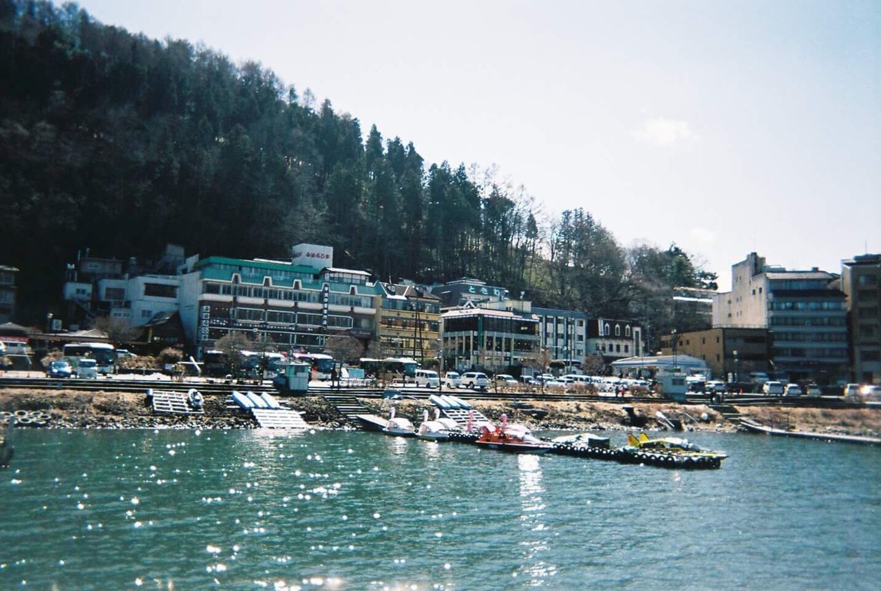 BOATS MOORED AT HARBOR IN CITY