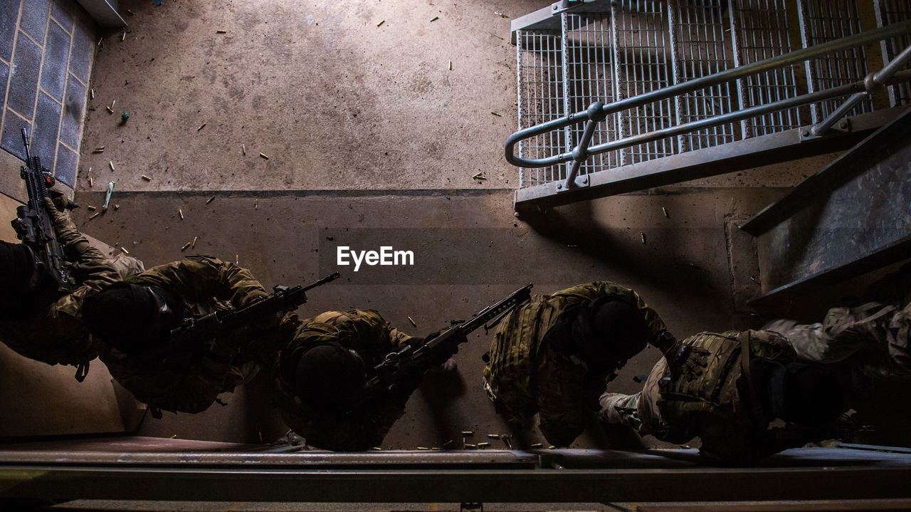 Directly above shot of army soldiers with rifles in abandoned building