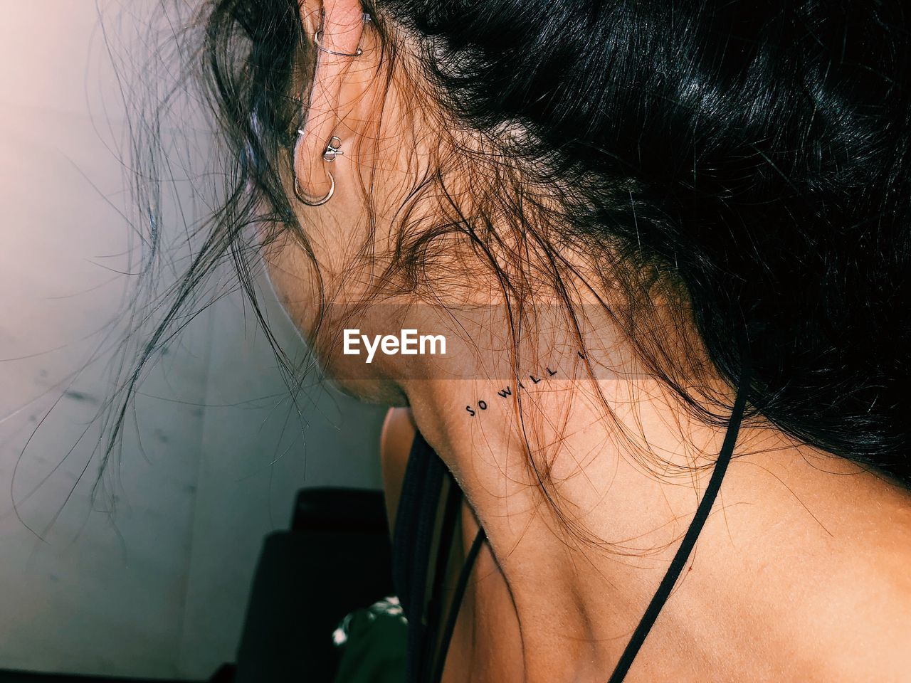 Woman showing text tattoo on her neck