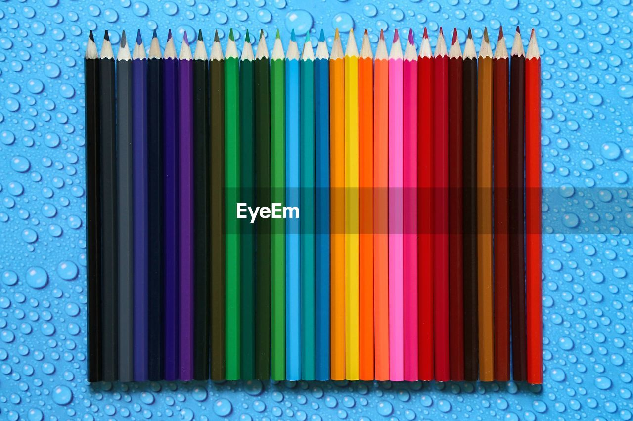 Close-up of colored pencils on wet table