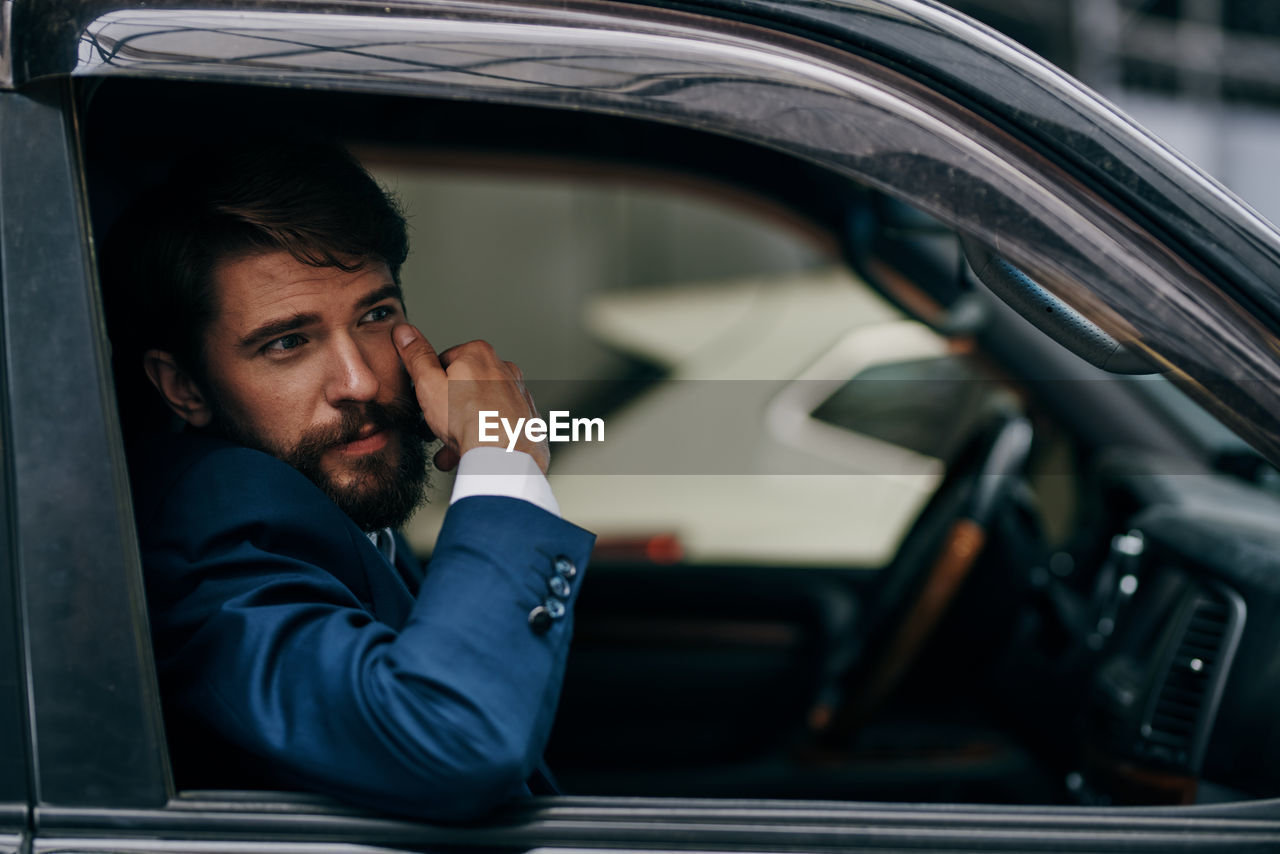 PORTRAIT OF YOUNG MAN WITH CAR IN BUS