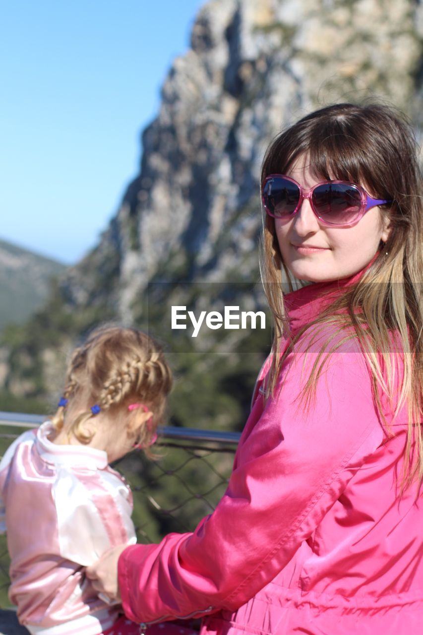 Portrait of woman with sunglasses holding daughter