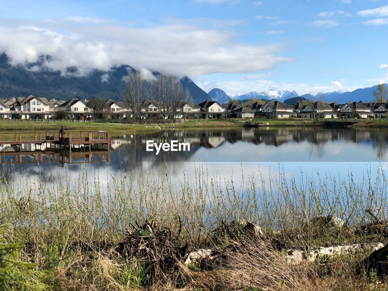 Scenic view of lake by buildings against sky