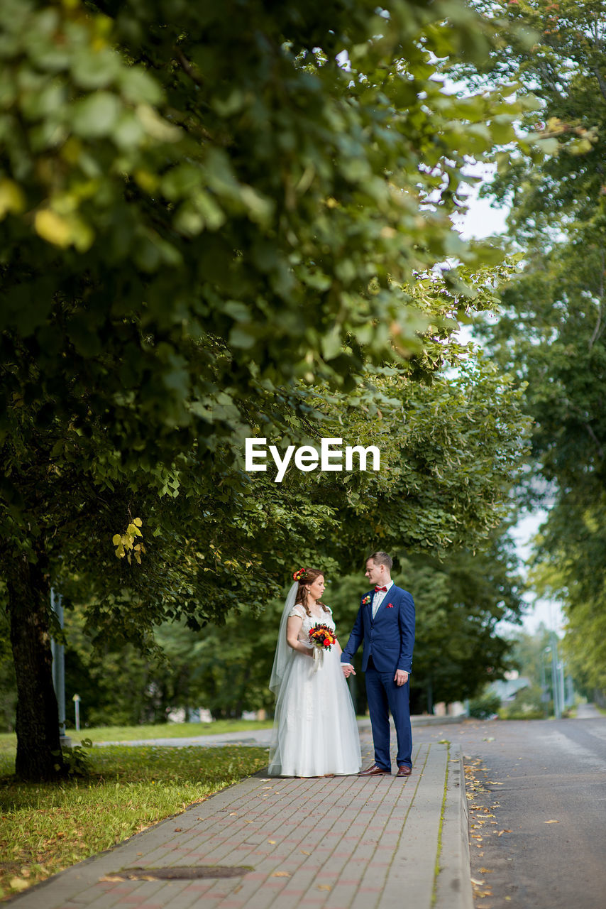 Bride and groom standing at park