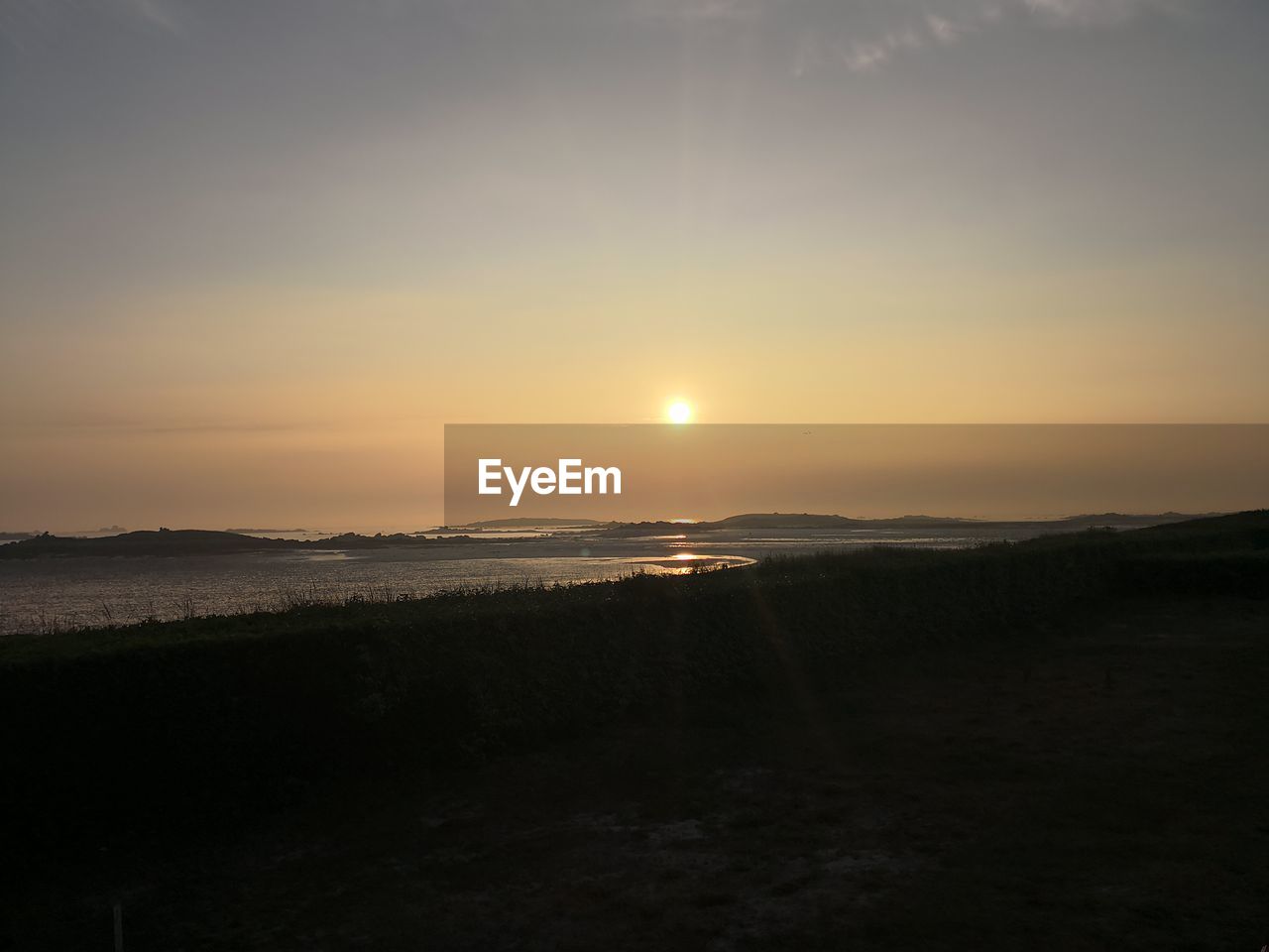 SCENIC VIEW OF SUNSET OVER WATER