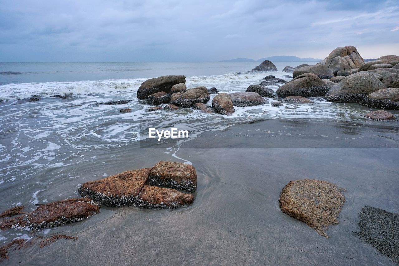 SCENIC VIEW OF ROCKS ON SHORE AGAINST SKY