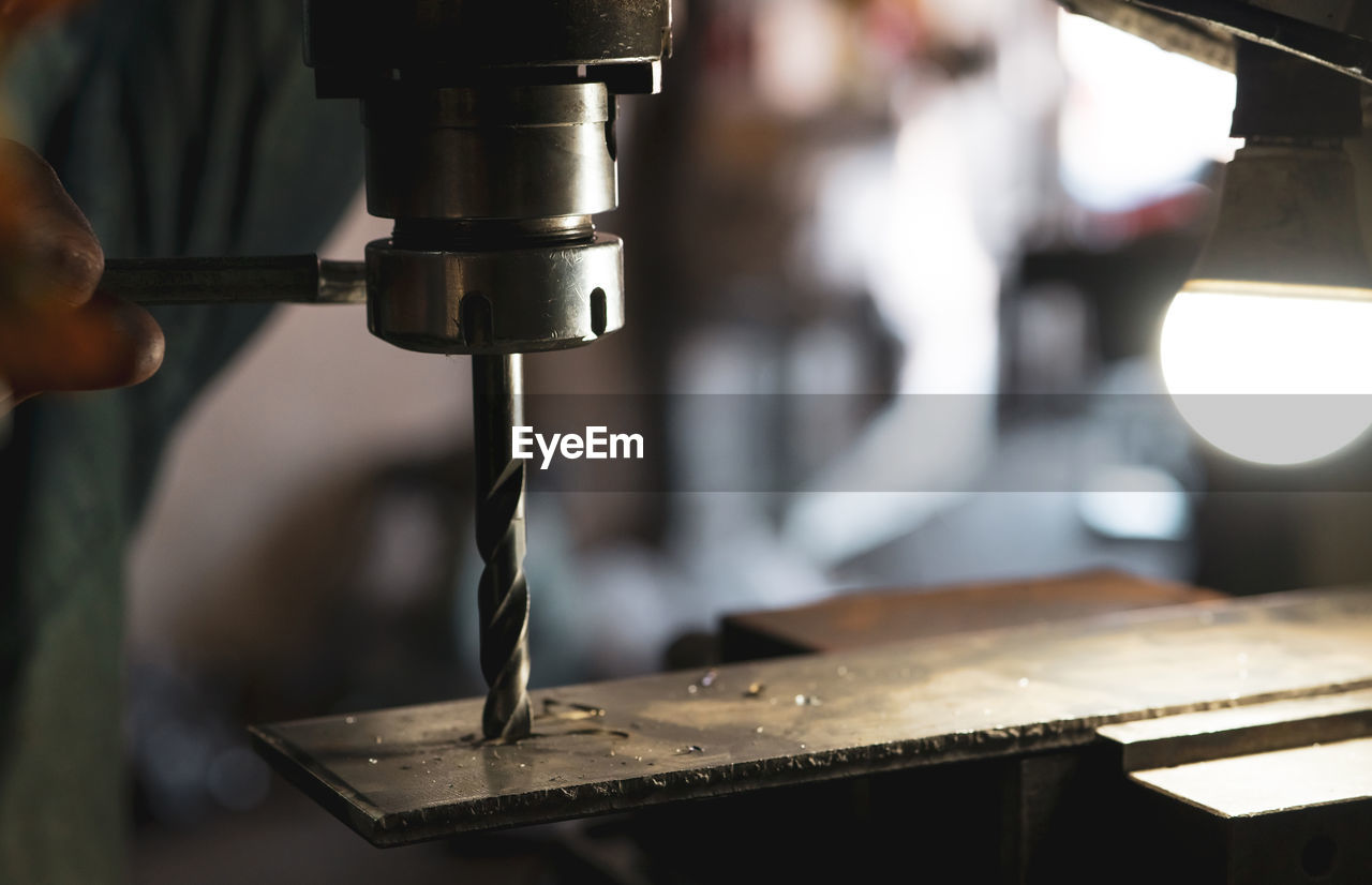 Worker hand working on milling machine to change metal drill bit. tool for drilling metal workpiece.