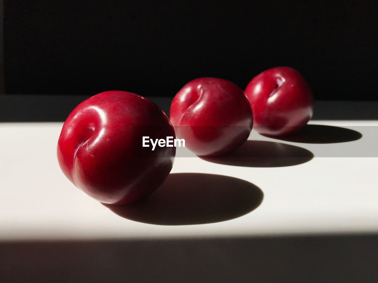 Close-up of red plums on table