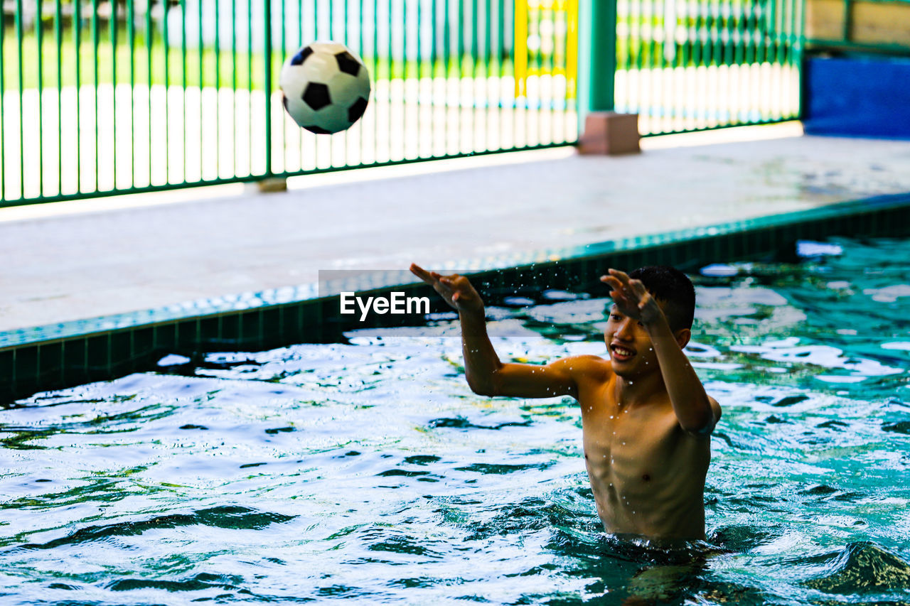 Man playing with ball in swimming pool