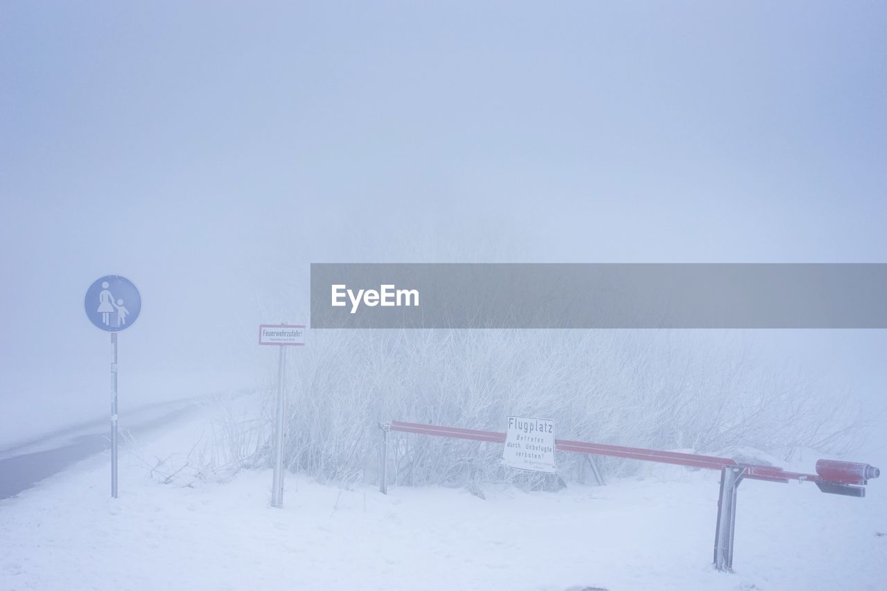 INFORMATION SIGN ON SNOW COVERED LANDSCAPE