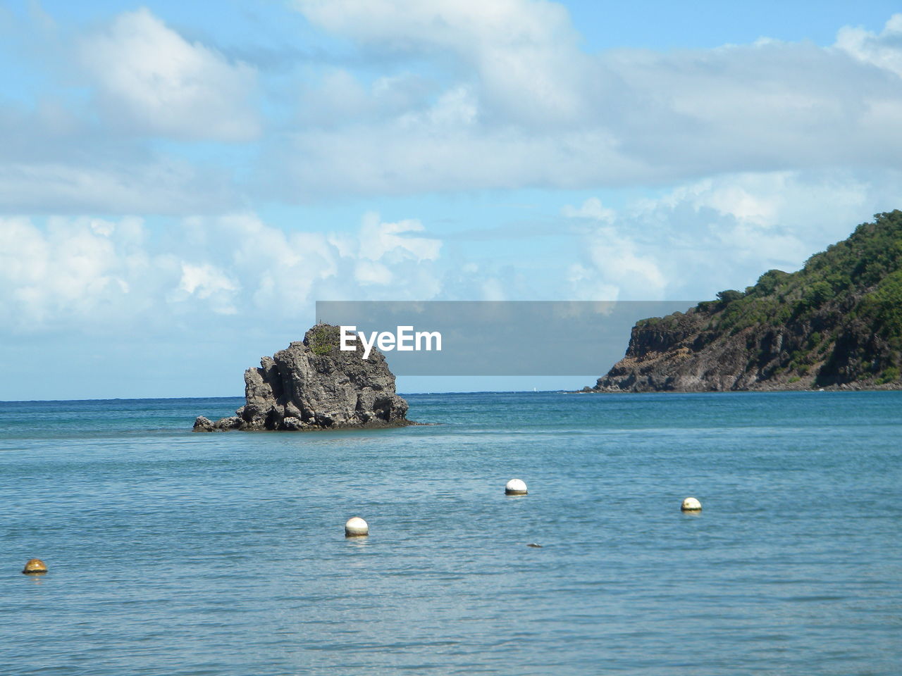 Scenic view of sea and tree mountains against sky