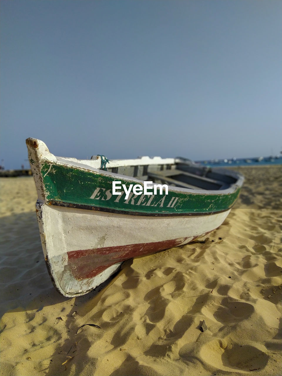 BOAT ON BEACH AGAINST CLEAR SKY