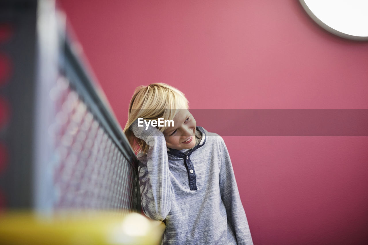 Thoughtful boy leaning on railing at middle school