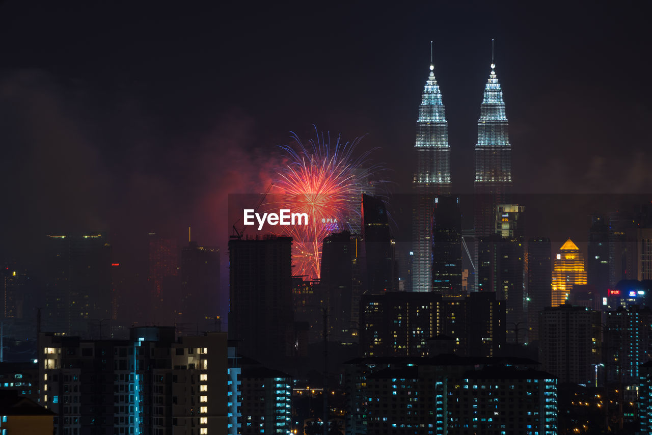 Illuminated petronas towers and fireworks at night