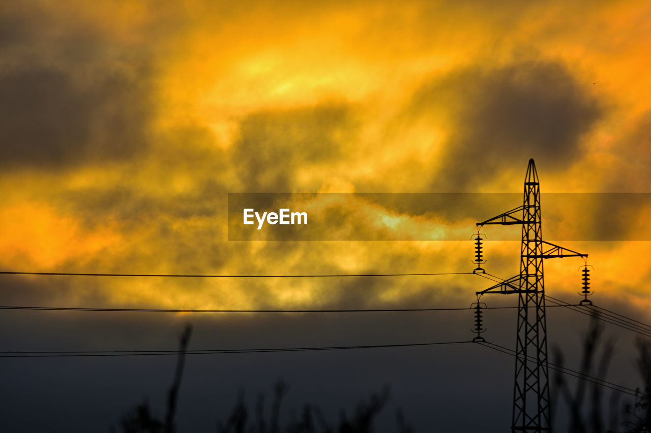 sky, electricity, technology, cable, cloud, electricity pylon, sunset, power supply, power line, power generation, silhouette, nature, orange color, dramatic sky, sunlight, no people, afterglow, communication, evening, outdoors, dusk, beauty in nature, low angle view, environment, built structure, scenics - nature, yellow, architecture, tree, overhead power line, industry