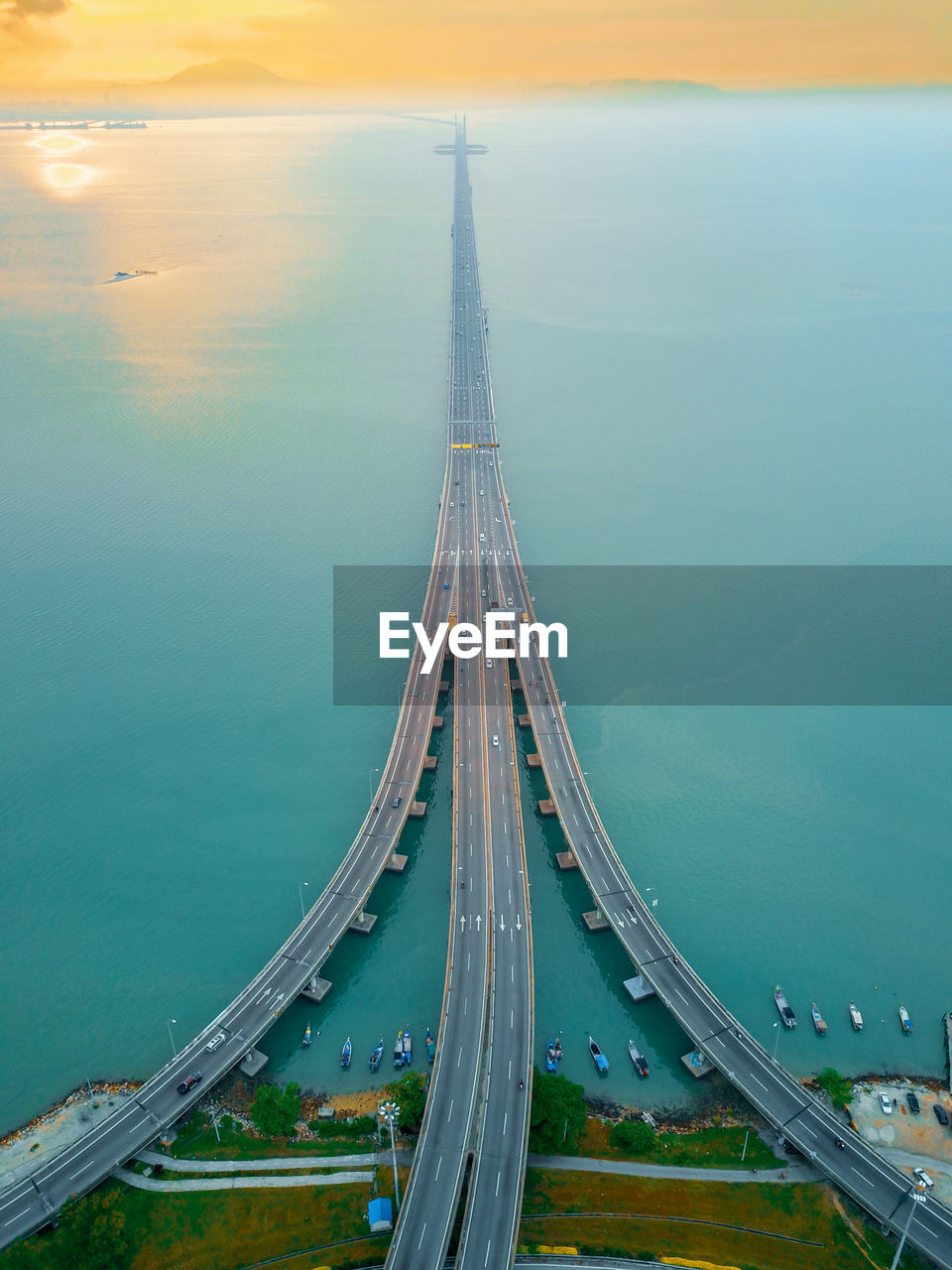 Aerial view of bridge over sea during sunset