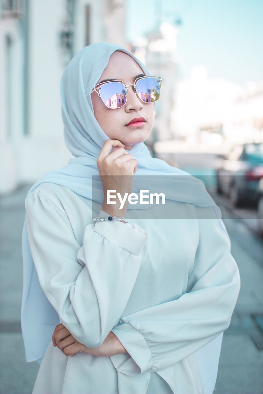 Young woman in traditional clothes wearing sunglasses while standing in city 