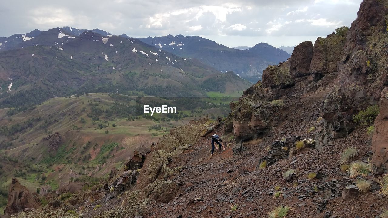 Woman standing on mountain against sky