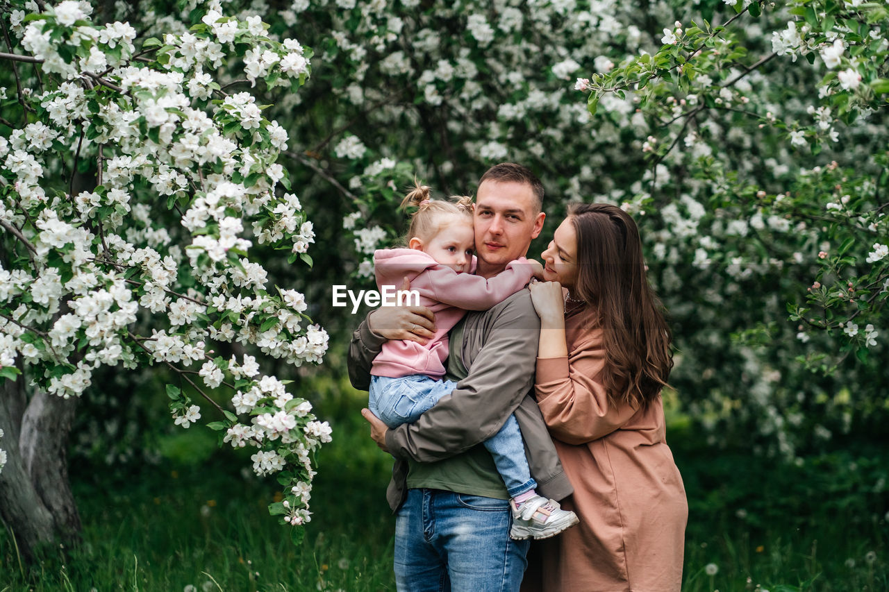 Family mom mom baby daughter in the garden blooming apple trees