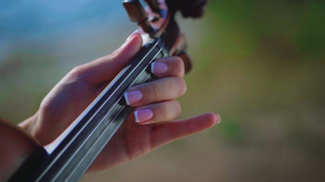 CLOSE-UP OF HAND PLAYING GUITAR