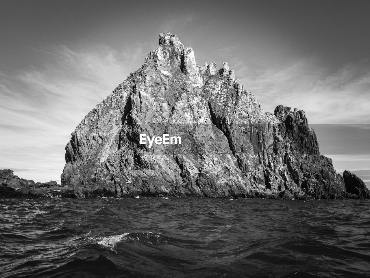 Black and white photo of sea with raw rocks in antarctica